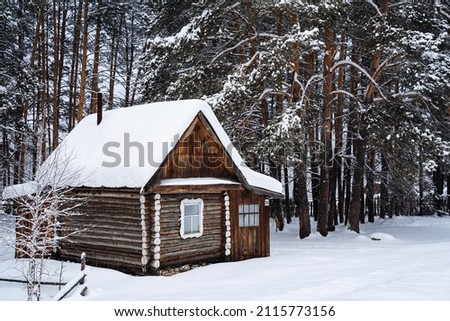 close shoot of a small country house in the middle of the forest by a country road. An old forester's house. Winter forest landscapes Royalty-Free Stock Photo #2115773156