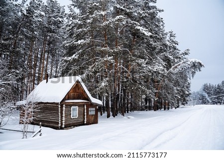 A small country house in the middle of the forest by a country road. An old forester's house. Winter forest landscapes Royalty-Free Stock Photo #2115773177