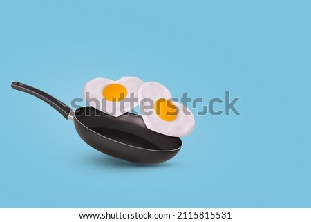 Creative idea with a frying pan and a two fried eggs in heart shape on a bright blue background. Minimal food and love concept. Breakfast idea for Valentine's day and romantic morning. Copy space.