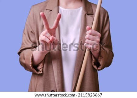 Woman teacher with success gesture on studio blue background, copy space