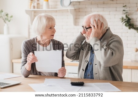 Senior elderly grandparents couple feeling shock sad in debts, bunkruptcy, negative test results, mortgage, divorce certificate contract pension, doing paperwork at home Royalty-Free Stock Photo #2115833792