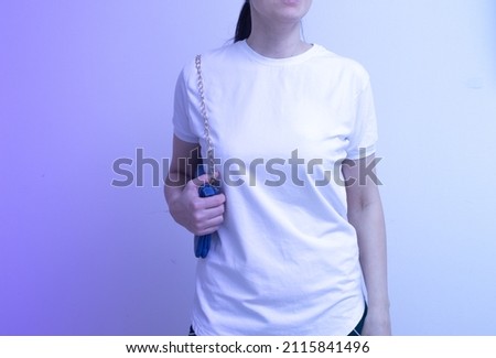 A young woman is dressed in blank white t-shirt mock-up for inscriptions, advertising, drawing.