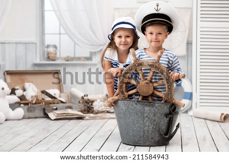 Boy and girl dressed as a captain and sailors played on the ship out of the bath in his room Royalty-Free Stock Photo #211584943