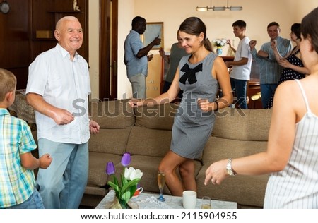 Large family with grandparents and children dancing at home