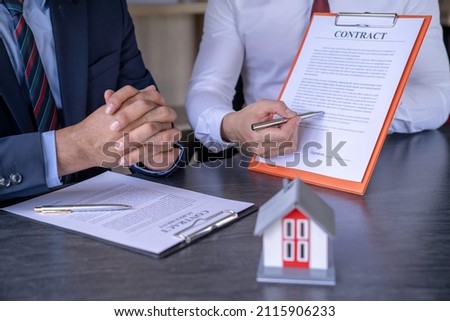 Real estate agents explain the document for customers who come to contact to buy a house, buy or sell real estate concept. home insurance ideas. home and land mortgage