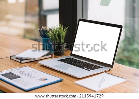 Laptop computer with blank white screen on table.