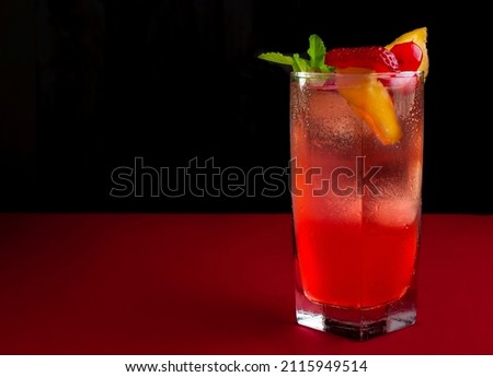 Chilled soft drink or punch on a table with a red tablecloth and a black background, copy space