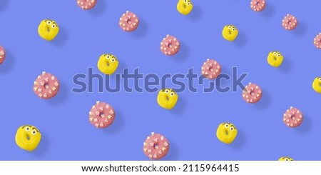 Colorful pattern of yellow and pink glazed donuts isolated on blue background with shadows. Doughnuts. Top view. Flat lay
