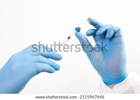 COVID-19 coronavirus vaccine. Vaccination concept. Doctor's hand in blue gloves hold medicine vaccine vial bottle and syringe. 