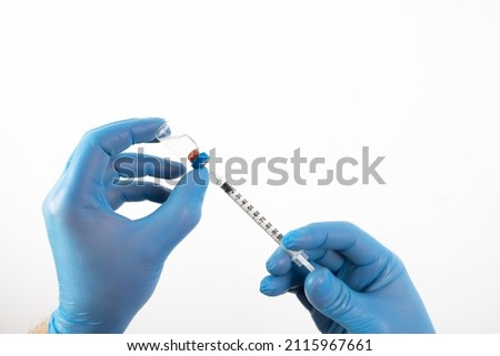 COVID-19 coronavirus vaccine. Vaccination concept. Doctor's hand in blue gloves hold medicine vaccine vial bottle and syringe.