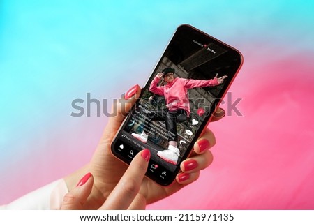 Sample social media app interface on mobile phone showing shared video content Royalty-Free Stock Photo #2115971435