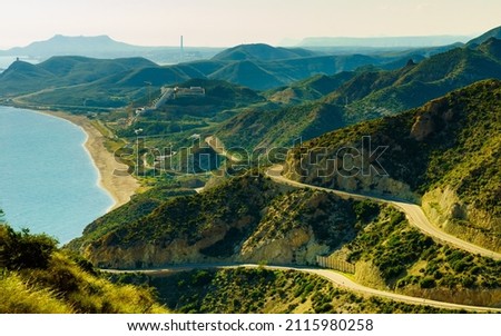 View from Granatilla Carboneras Viewpoint of hilly landscape and curved road. Cabo de Gata Natural Park, provincia Almeria, Spain. Royalty-Free Stock Photo #2115980258