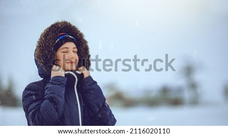 Portrait of a Nice Female Enjoying Snowfall with Closed Eyes of Pleasure. Having Fun in Cold Winter Weather. Happy Life.