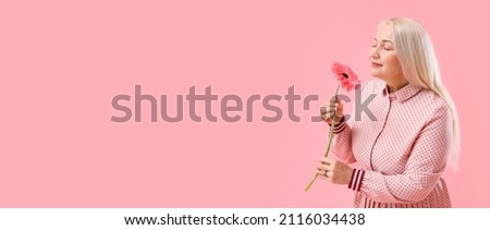 Beautiful mature woman with aromatic flower on pink background with space for text. International Women's Day celebration