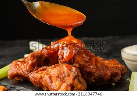 Classic buffalo wings topped with sauce. BBQ wings. Royalty-Free Stock Photo #2116047746
