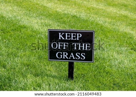 Keep Off the Grass sign on a nicely kept lawn in a park