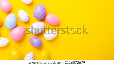 Multicolored easter eggs on yellow background. Easter concept. Top view. Copy space