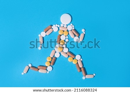 Abstract man made of medical pills on blue background. Nutritional supplements and vitamins concept