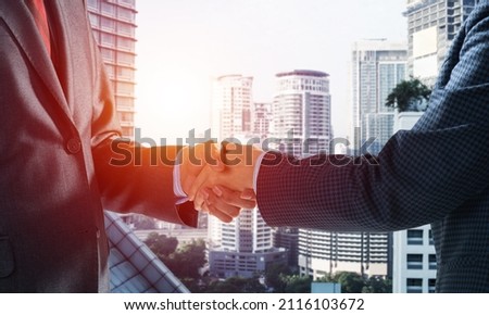 Close-up of the handshake of businessmen. Against the backdrop of the cityscape