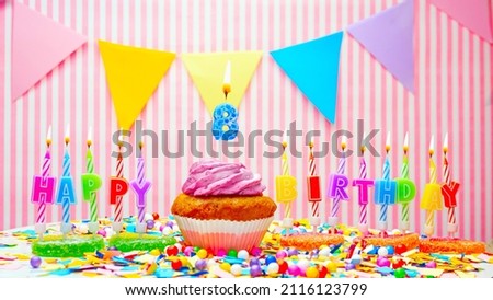Happy birthday number 8. On a pink background, a happy birthday greeting for an eight year old child. Muffins with pink cream with a burning candle. Copy space