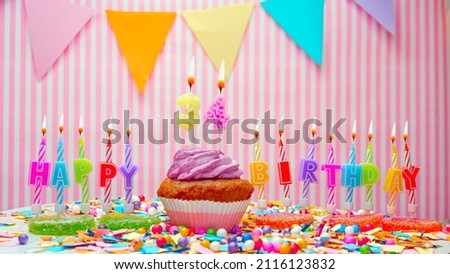 Happy birthday number 34. On a pink background, congratulations on the birthday of thirty four years old. Muffins with pink cream with a burning candle. Copy space