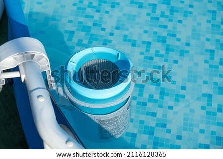 Skimmer on a round frame pool of a country house. Blue skimmer to clean pool in clear water. Side view from above Royalty-Free Stock Photo #2116128365