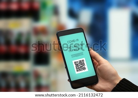 proof of vaccination for a grocery store,hand with qr code on phone to visit supermarket