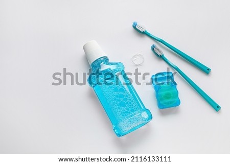 Dental floss with tooth brushes and rinse on white background Royalty-Free Stock Photo #2116133111