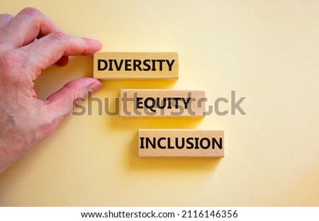 Diversity equity inclusion symbol. Concept words diversity equity inclusion on blocks on beautiful white table white background. Businessman hand. Business, diversity equity inclusion concept.