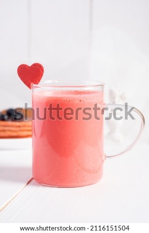 Red milkshake with a decoration in the form of a heart. Concept Valentine's Day. Vertical orientation