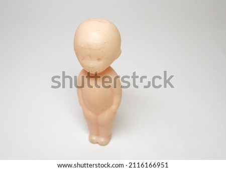baby toy plastic figure. little boy, standing straight. Doll with no moving parts. Head with bangs on forehead. selective focus Royalty-Free Stock Photo #2116166951