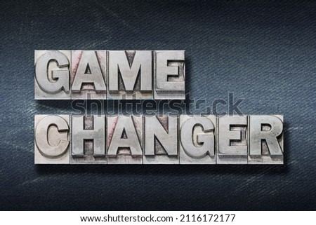 game changer phrase made from metallic letterpress on dark jeans background