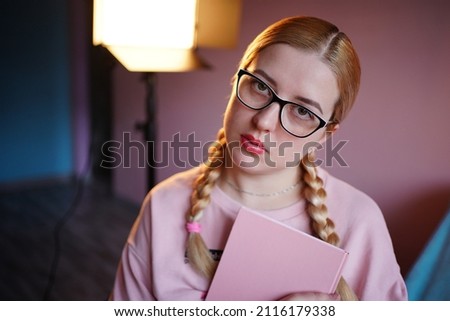 girl student in glasses with a notebook. High quality photo