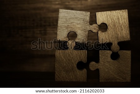 4 Four brown pieces of puzzle stand on wooden table isolated on white background. empty copy space for inscription or objects. idea, sign, symbol, concept of connecting. Brainstorming