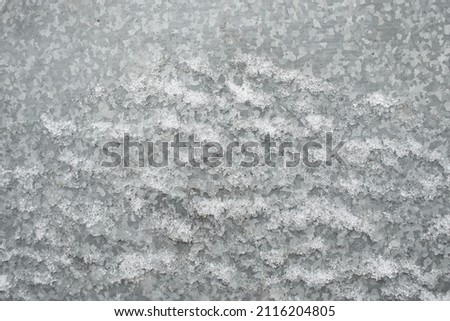 Zinc galvanized sheet of metal covered with ice snow. Can be used as background or texture