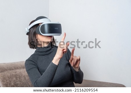 Teen girl using vr headset is in virtual reality cyberspace. The concept of the metaverse, virtual reality, virtual social universe