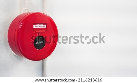 Fire alarm emergency switch push button for safety system control on building wall background in office, factory or school 