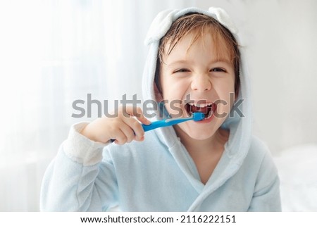 Morning routine, smiling happy child brushing teeth with toothbrush. Dental hygiene of little boy, medical care. Royalty-Free Stock Photo #2116222151