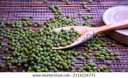 Green beans on the kitchen table, that are ready to be processed into porridge and some wooden tableware give a minimalist impression. The concept of food and drink. Food Photography. Selective focus.