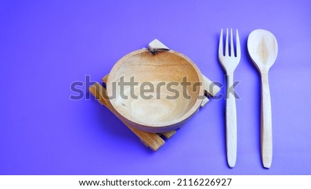 Wooden kitchenware that gives a classic and minimalist impression. Food and drink concept. Food Photography. Blue background. Wooden Bowl on the table.