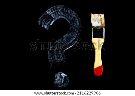 Question mark painted on a black background. White question mark. High quality photo