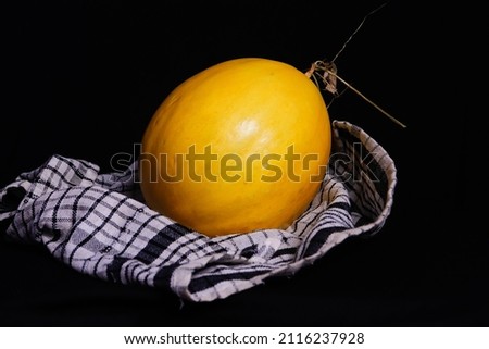 picture of golden melon with red flesh on a black background