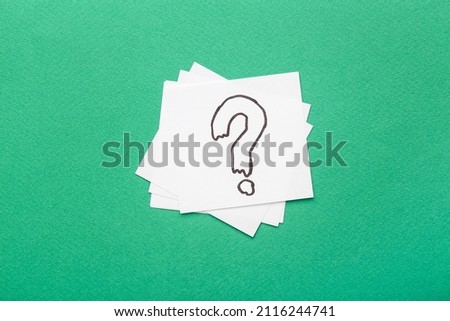 White sticky notes with question mark on green background
