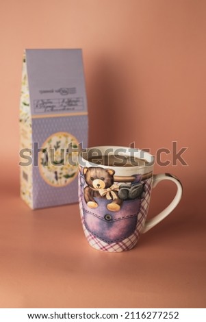 a cup with a picture of a bear and a mouse with a lilac tea package.
text translation: herbal tea, thyme, St. John's wort, chamomile, lavender juniper 