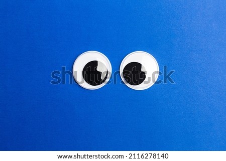 Googly eyes on a blue background with copy space