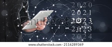 New year concept. Hand touch tablet with digital hologram 2022 sign