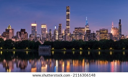 New York City skyline. Midtown Manhattan skyscrapers from Central Park Reservoir at Dusk. Evening view of illuminated luxury skyscrapers