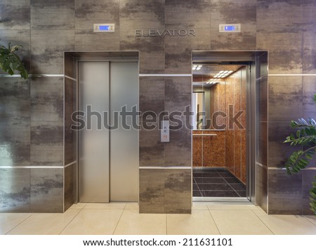 Two elevators in hotel lobby Royalty-Free Stock Photo #211631101