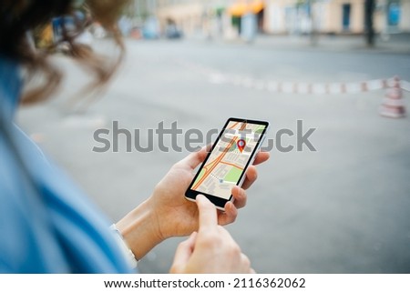 Woman tourist use maps app to navigate city, plan route from location to destination Royalty-Free Stock Photo #2116362062