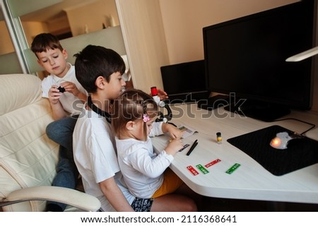 Kids using microscope learning science class at home.